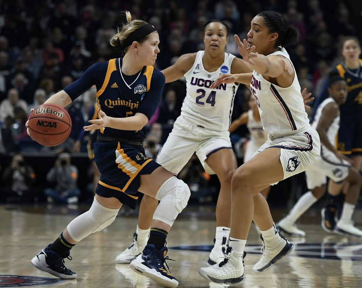 Quinnipiac’s Carly Fabbri, left, passes under pressure from UConn’s Napheesa Collier, center, and Gabby Williams, right, during the first half of a second-round game in the NCAA Tournament on Monday in Storrs.