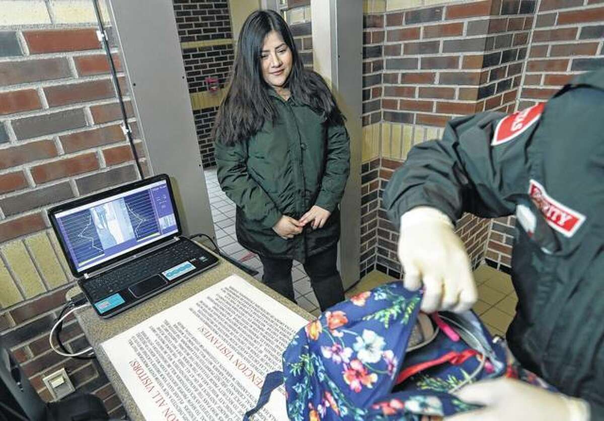 Alondra Alvarez, a student at Western International High School in Detroit, goes through a metal detector and has her backpack checked in early March as she enters the school. Experts say metal detectors and other security measures put in place decades ago to quell gang and other violence in many urban schools have made them tough targets for mass shootings by troubled students or outsiders.