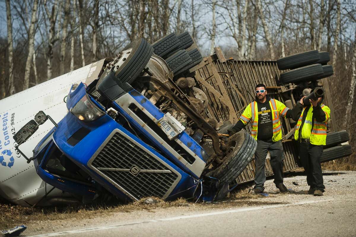 A crew from Mike's Wrecker Service prepares to right a tractor-trailer after it flipped while driving on W. Pine River Road near Porter Road on Tuesday, March 20, 2018 in Midland County. (Katy Kildee/kkildee@mdn.net)
