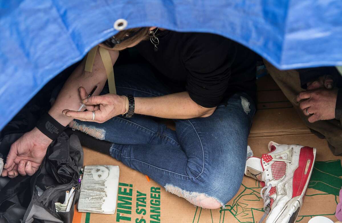 Ladybird shoots up heroine inside her tent along 13th Street near Harrison Street Tuesday, March 20, 2018 in San Francisco, Calif.