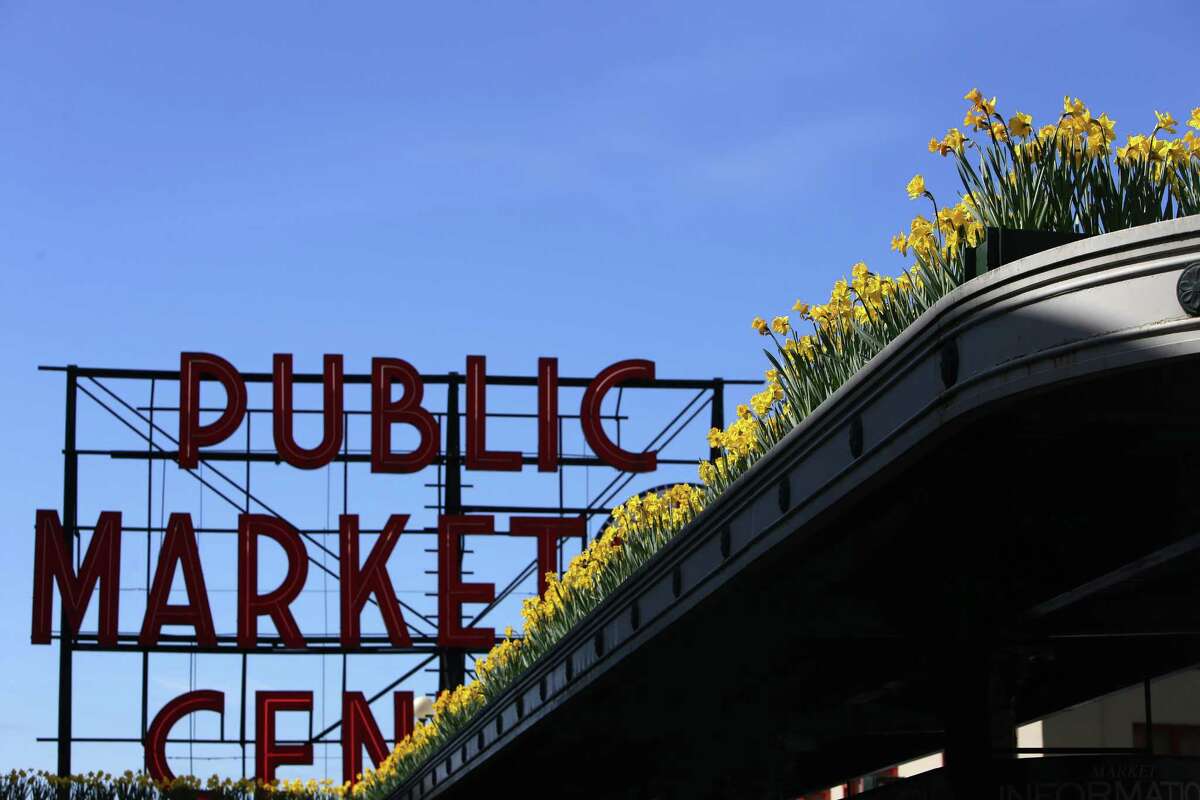 Daffodils line a rooftop at Pike Place, Tuesday, March 20, 2018. Dozens of volunteers handed out over 9,000 locally grown daffodils to people throughout downtown Seattle, Tuesday afternoon, to celebrate the first day of spring. This is the 21st annual Pike Place Market Daffodil Day.