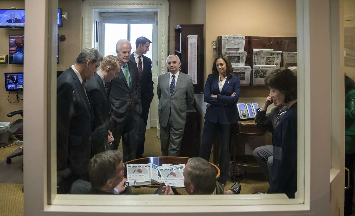 Senate Intelligence Committee Vice Chairman Mark Warner, D-Va., seated left, with Chairman Richard Burr, R-N.C., seated right, confer with committee members prior to a news conference on improving the nation's election infrastructure.