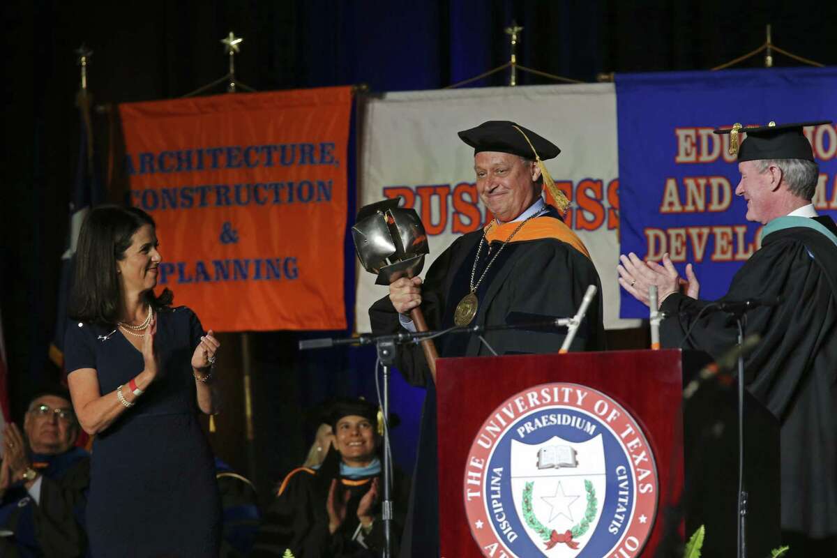University of Texas at San Antonio President Taylor Eighmy holds the university mace during his inauguration ceremony at the convocation center. Joining Eighmy on stage is his wife, Peggy, and University of Texas System Chancellor William McRaven.
