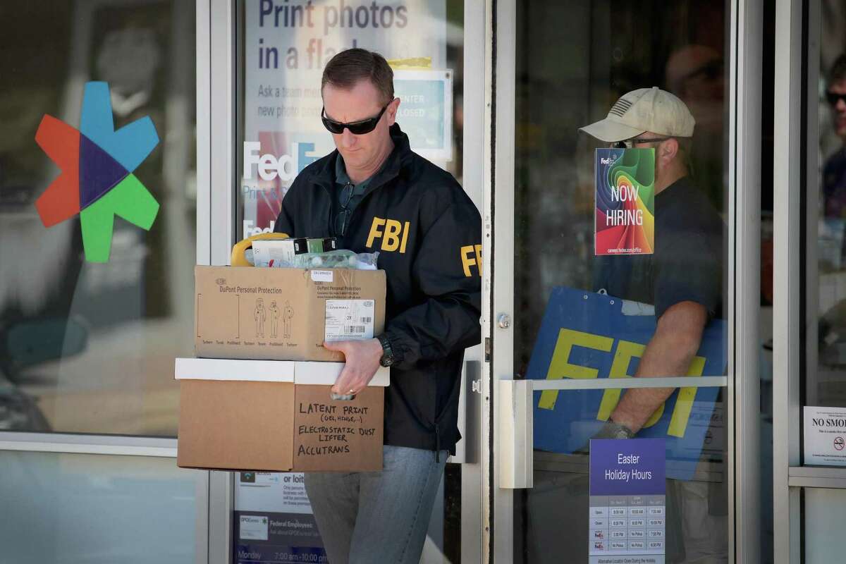 SUNSET VALLEY, TX - MARCH 20: FBI agents collect evidence at a FedEx Office facility following an explosion at a nearby sorting center on March 20, 2018 in Sunset Valley, Texas. A package, reported to have been shipped from this store, exploded while being transported on a conveyor shortly after midnight this morning at the sorting facility in Schertz, Texas causing minor injuries to one person. The explosion is believed to be related to several recent package bombs that have been detonated in Austin, Texas. (Photo by Scott Olson/Getty Images)