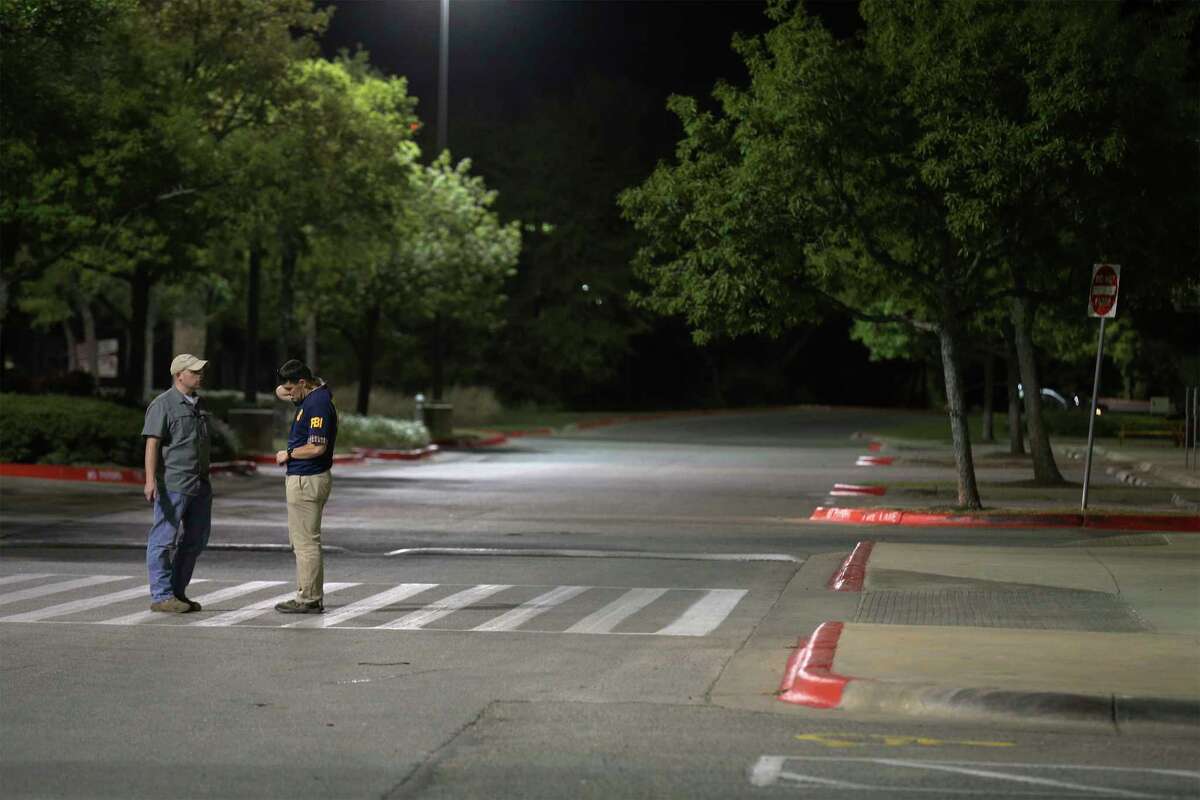 An FBI official along with an individual stand in the street near a Randall's along Slaughter and Brodie Lanes in South Austin near where an incendiary device caused law enforcement to be alarmed that another bomb had been discovered on Tuesday, Mar. 20, 2018. Officials stated that the device was not linked to the series of bombings that have occurred in Austin that has taken lives and forced the community to be on high alert.