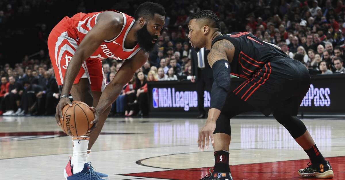 Houston Rockets guard James Harden looks to get past Portland Trail Blazers guard Damian Lillard during the first half of an NBA basketball game in Portland, Ore., Tuesday, March 20, 2018. (AP Photo/Steve Dykes)
