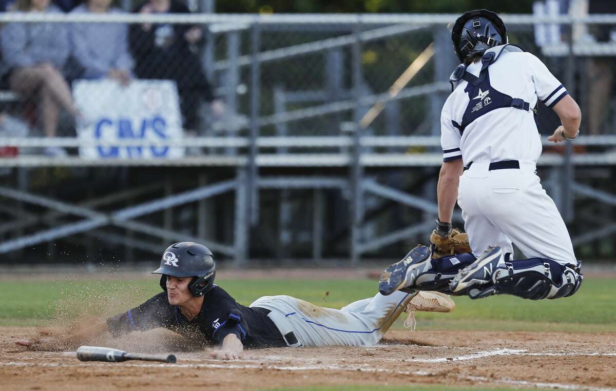 Oak Ridge's Carson Ogilvie slides past College Park catcher Josh Trahan to score on Logan Letney's ground out during the third inning of a District 12-6A high school baseball game at College Park High School, Tuesday, March 20, 2018, in The Woodlands.