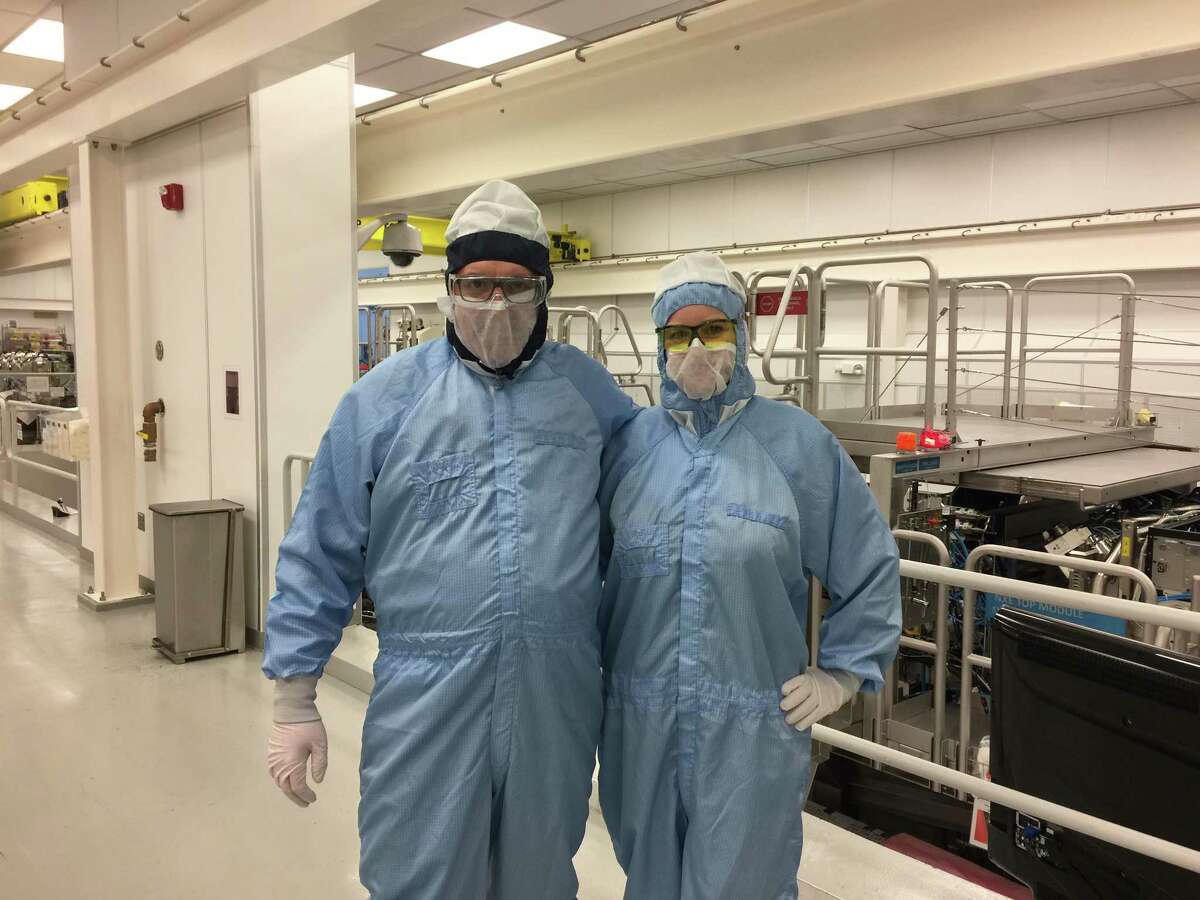 Times Union reporter Larry Rulison, left, at ASML's manufacturing clean room in Wilton, Conn. on Monday, March 19, 2018. At right is ASML publicist Amy Rice. ASML is expanding its facilities as it ramps up making extreme ultraviolet lithography machines used to make cutting edge computer chips.