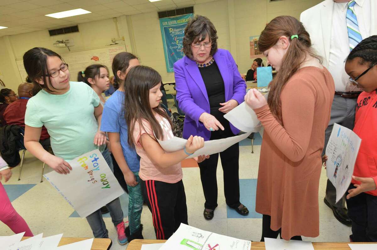 Courage to Speak Foundation Founder Ginger Katz looks at posters and letters from Brookside School’s Maria Valencia and Samantha Wehrle during the 14th annual Empowering Youth to be Drug Free Family Night at Roton Middle School in Norwalk on Tuesday. Students wrote letters and created anti-drug posters for the event, which incuded a pizza and pasta dinner, plus guest speakers and a video presentation.