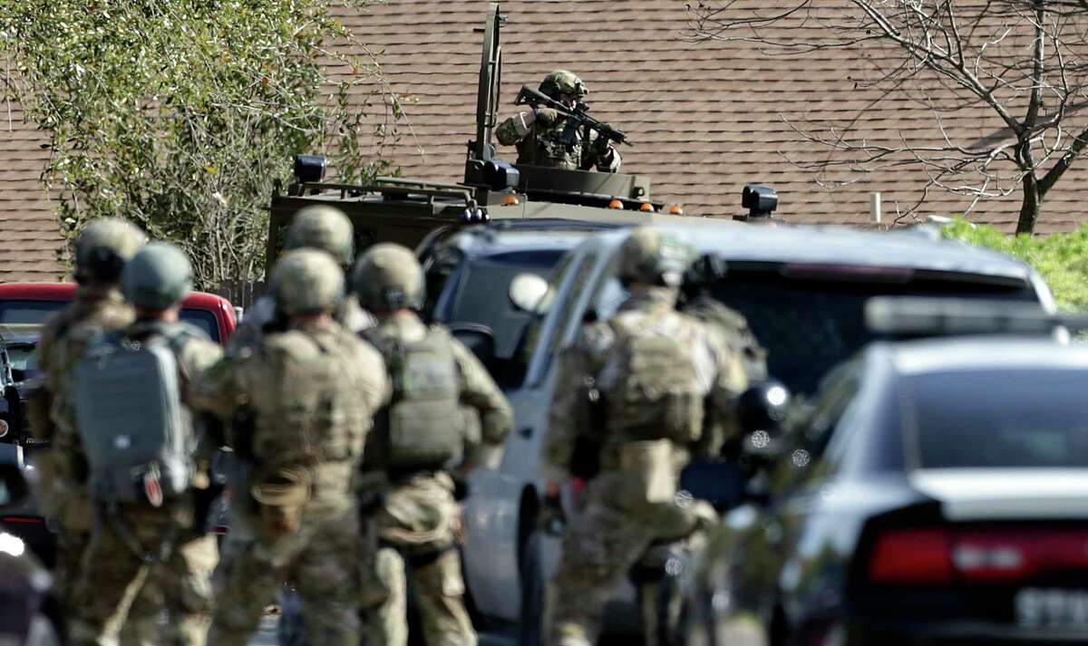FBI SWAT members cover as the home is breached at the scene of Walnut and 2nd Street in Pflugerville where bombing suspect lived on March 21, 2018.