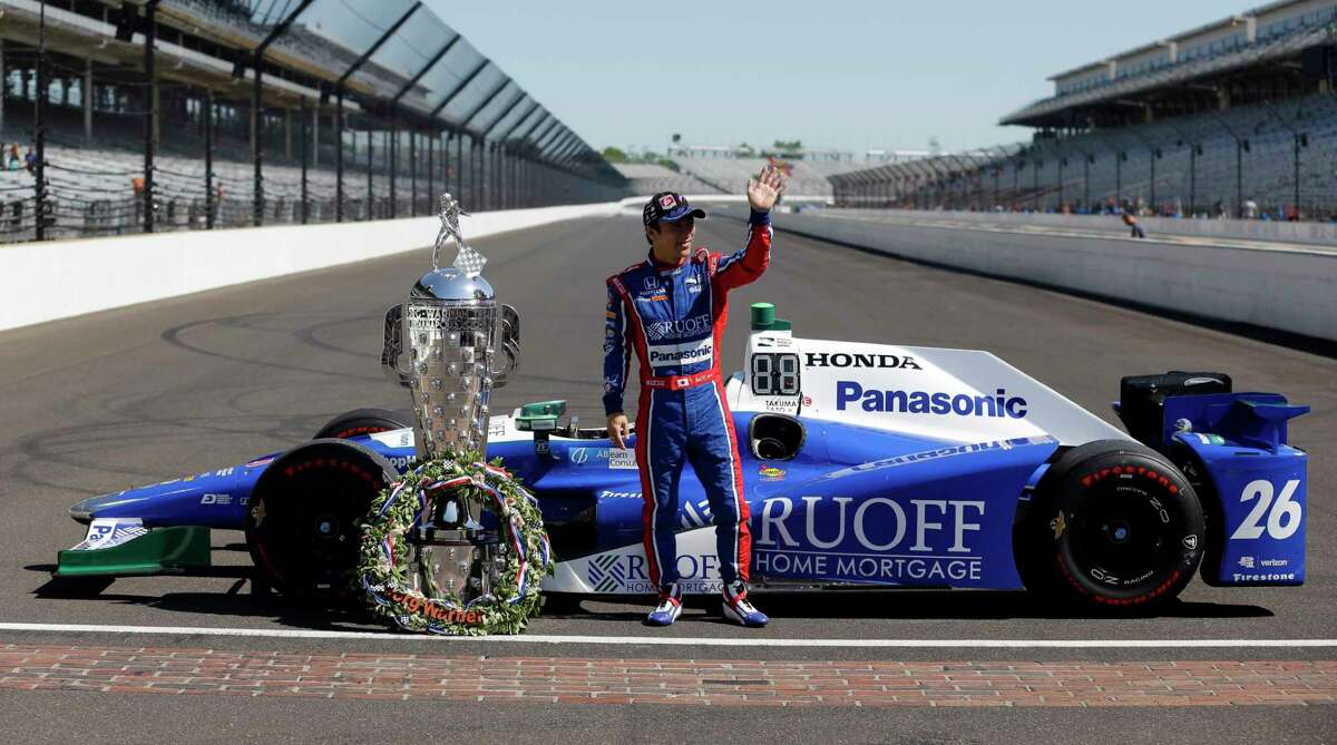 Indianapolis 500 champion Takuma Sato, of Japan, poses with the Borg-Warner Trophy during the traditional winners photo session on the start/finish line at the Indianapolis Motor Speedway in Indianapolis, Monday, May 29, 2017. (AP Photo/Michael Conroy)