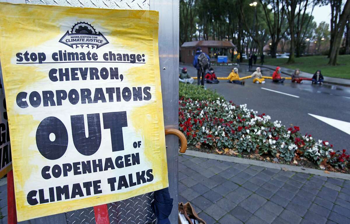 In this Dec. 7, 2009, file photo, demonstrators block the main entrance of Chevron Corp. in San Ramon. A federal judge presiding over lawsuits accusing big oil companies of lying about global warming is turning his courtroom into a classroom. 
