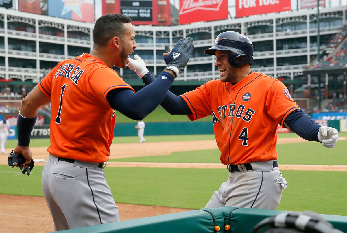 Houston Astros' Carlos Correa (1) and George Springer (4) celebrate Springer's grand slam in the sixth inning of a baseball game against the Texas Rangers on Wednesday, Sept. 27, 2017, in Arlington, Texas. (AP Photo/Tony Gutierrez)