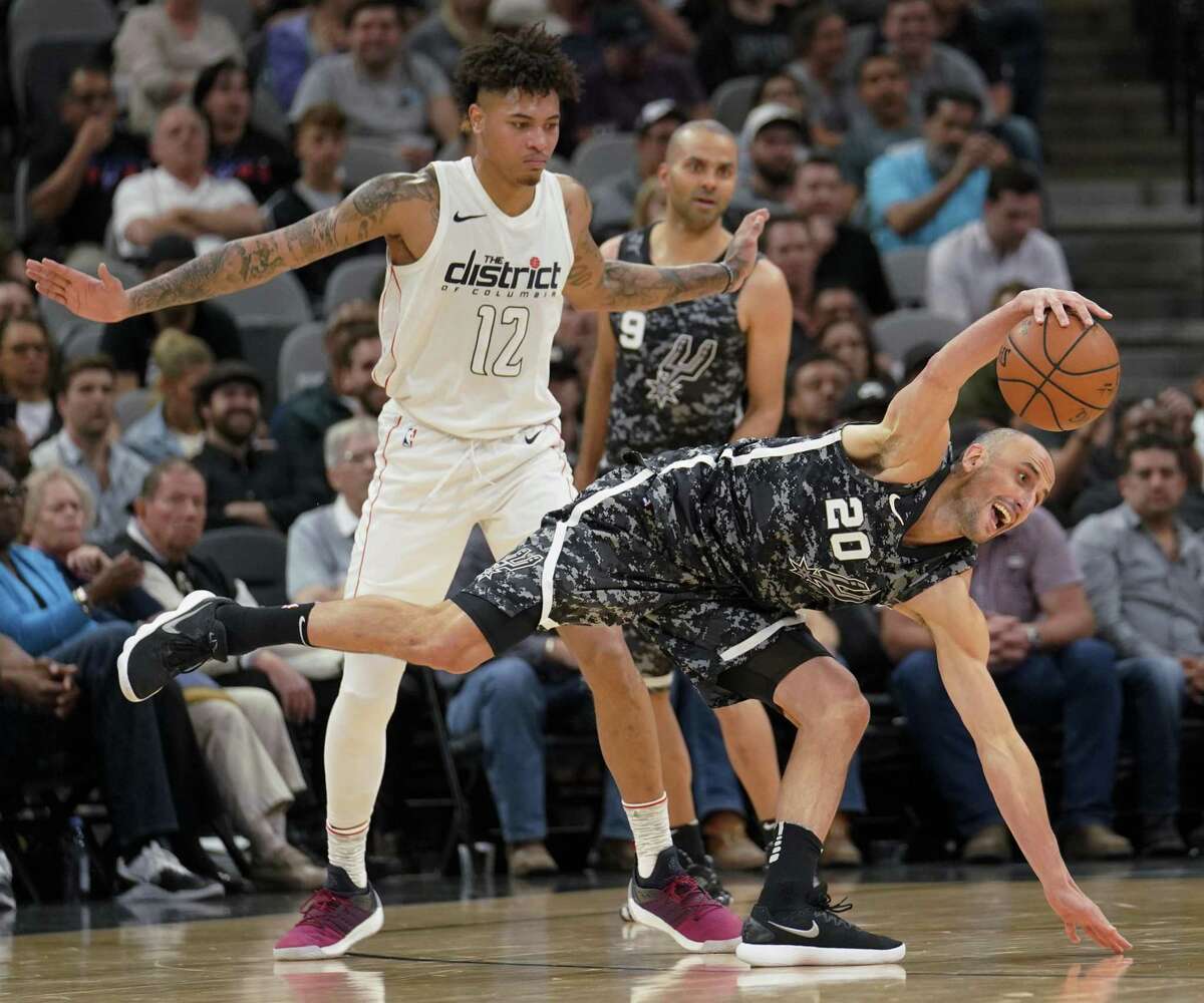 San Antonio Spurs' Manu Ginobili (20) fights for possession against Washington Wizards' Kelly Oubre Jr. during the first half of an NBA basketball game Wednesday, March 21, 2018, in San Antonio.