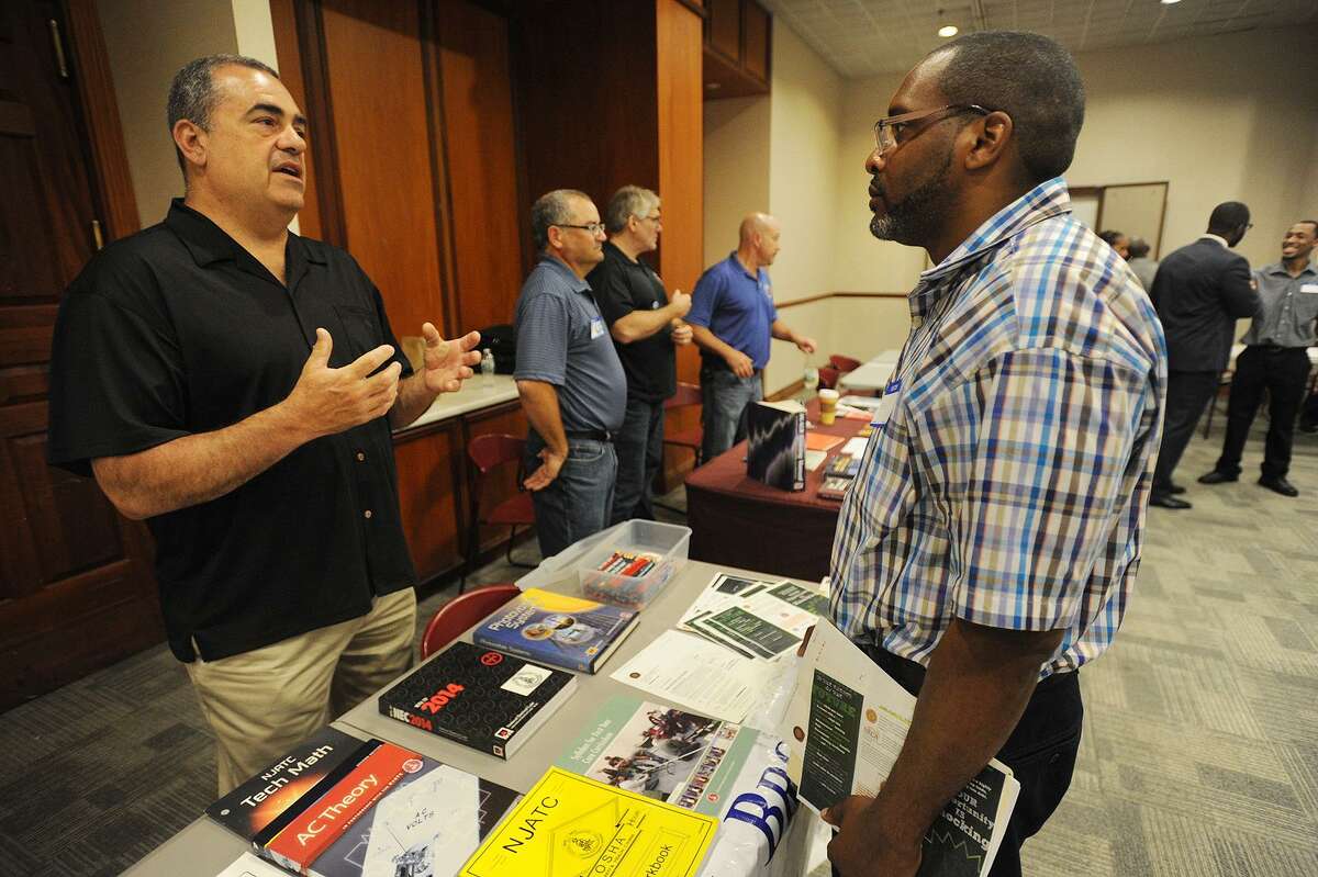Sean Toliver, right, of Bridgeport, talks with Thomas Sportini, training director for IBEW Local 488 electrical workers union, at the Bridgeport Re-Entry Career Fair, at the Margaret Morton Government Center in Bridgeport, Conn., on June 28, 2017.