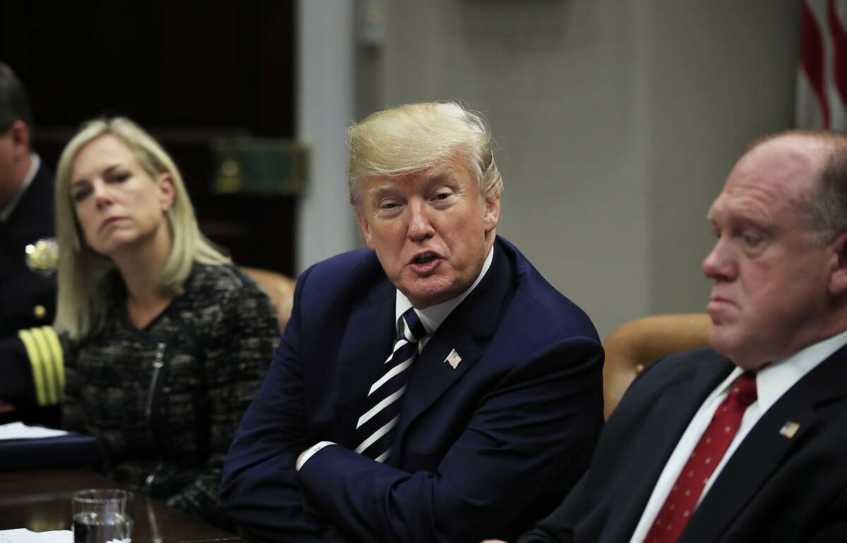 President Donald Trump with Homeland Security Secretary Kirstjen Nielsen, left, and Immigration and Customs Enforcement Deputy Director Thomas Homan, right, speaks during a roundtable talks on sanctuary cities with law enforcement officers in the Roosevelt Room of the White House, in Washington, Tuesday, March 20, 2018. (AP Photo/Manuel Balce Ceneta)