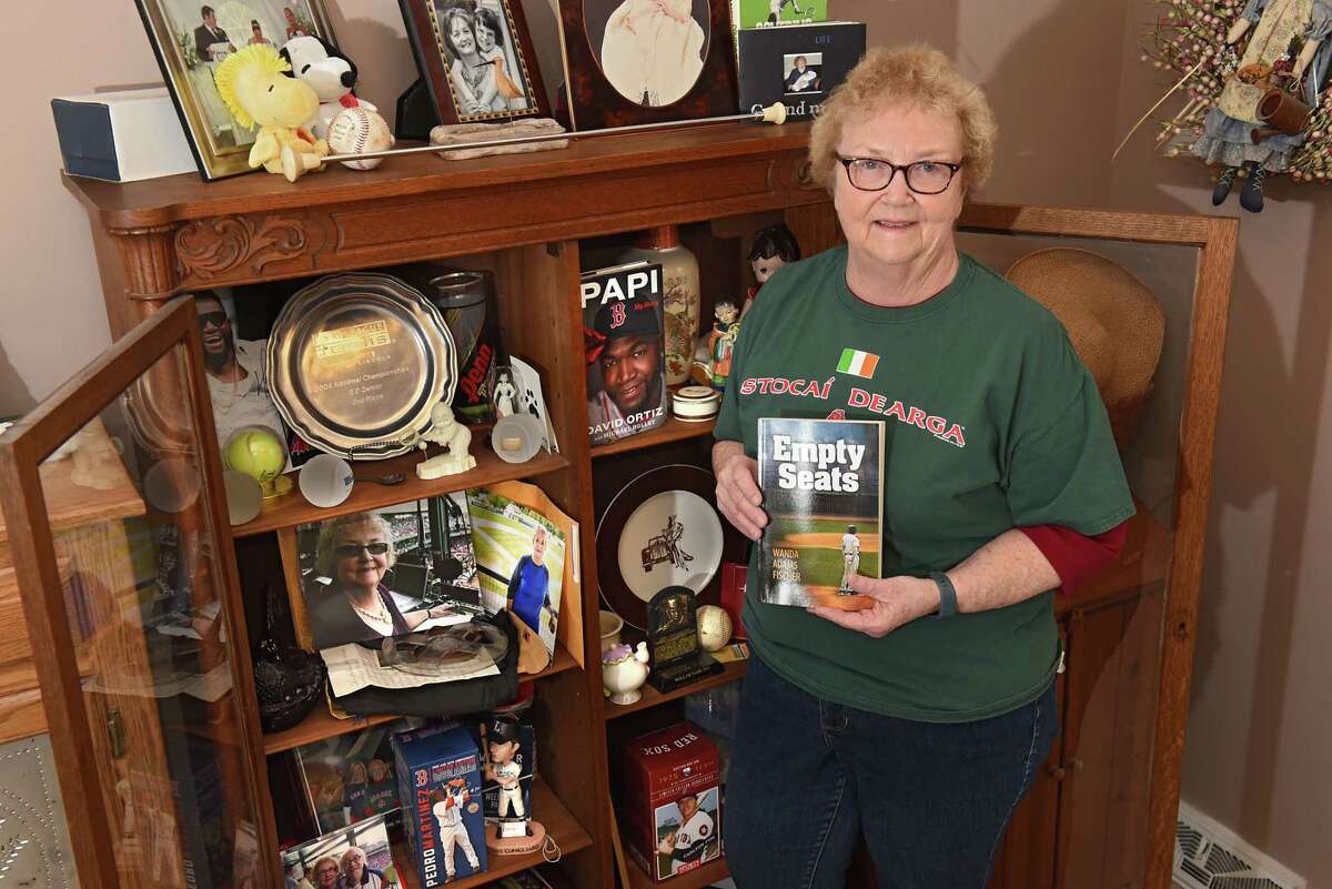 Wanda Fischer stands next to her baseball paraphernalia at her Schenectady home in 2018. Her coming-of-age novel about baseball is titled "Empty Seats." In 20212, she was a guest announcer at Fenway Park in Boston, calling a game between the Red Sox and the Minnesota Twins.