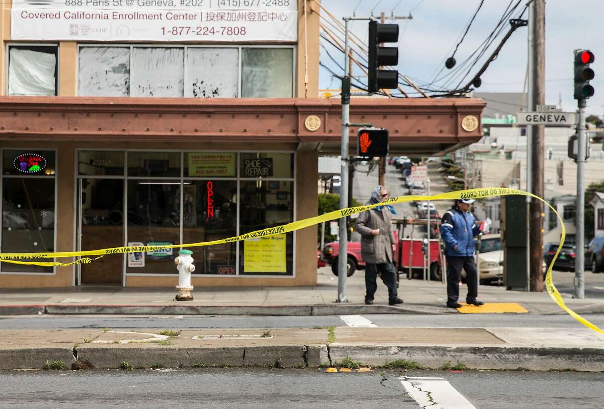 Crime scene tape whips in the wind as pedestrians cross Geneva Avenue Thursday, March 22, 2018 in San Francisco, Calif. following a shooting that occurred nearby at Amazon Barber Shop Wednesday, March 21.