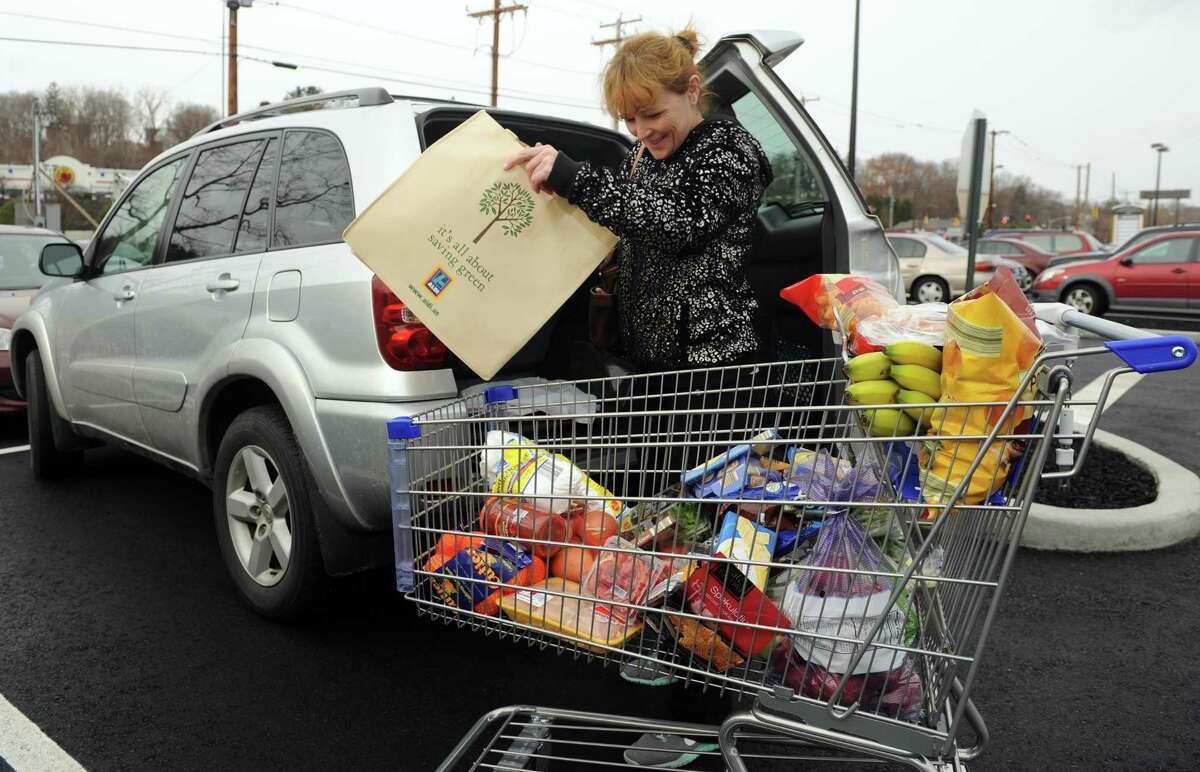 Danuta Gul, of Ansonia, unloads her shopping cart Thursday, Dec. 11, 2014, at the new ALDI supermarket in Derby, Conn. Gul, originally from Poland, is familiar with the grocery chain which has stores across Europe.