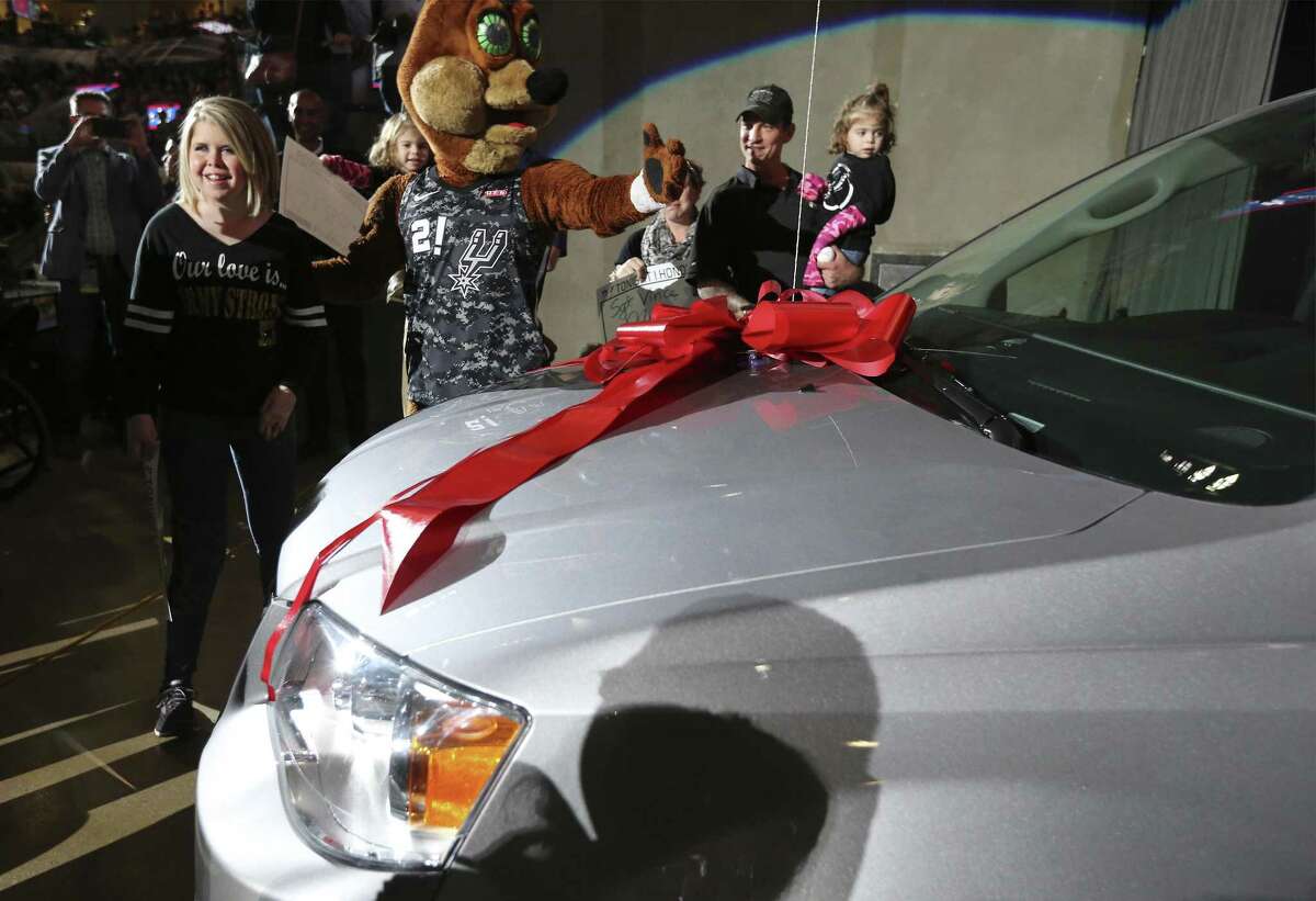 Spurs Coyote helps Sarah Merriman (left) toward a new van that was given to her during the Spurs’s Military Appreciation Night at the AT&T Center on Wednesday, Mar. 21, 2018. The vehicle was provided by the nonprofit Wish for Our Heroes, which teamed up with USAA, Lone Star Auto Group and the San Antonio Spurs. Merriman has endured a series of health problems while raising twin daughters. (Kin Man Hui/San Antonio Express-News)