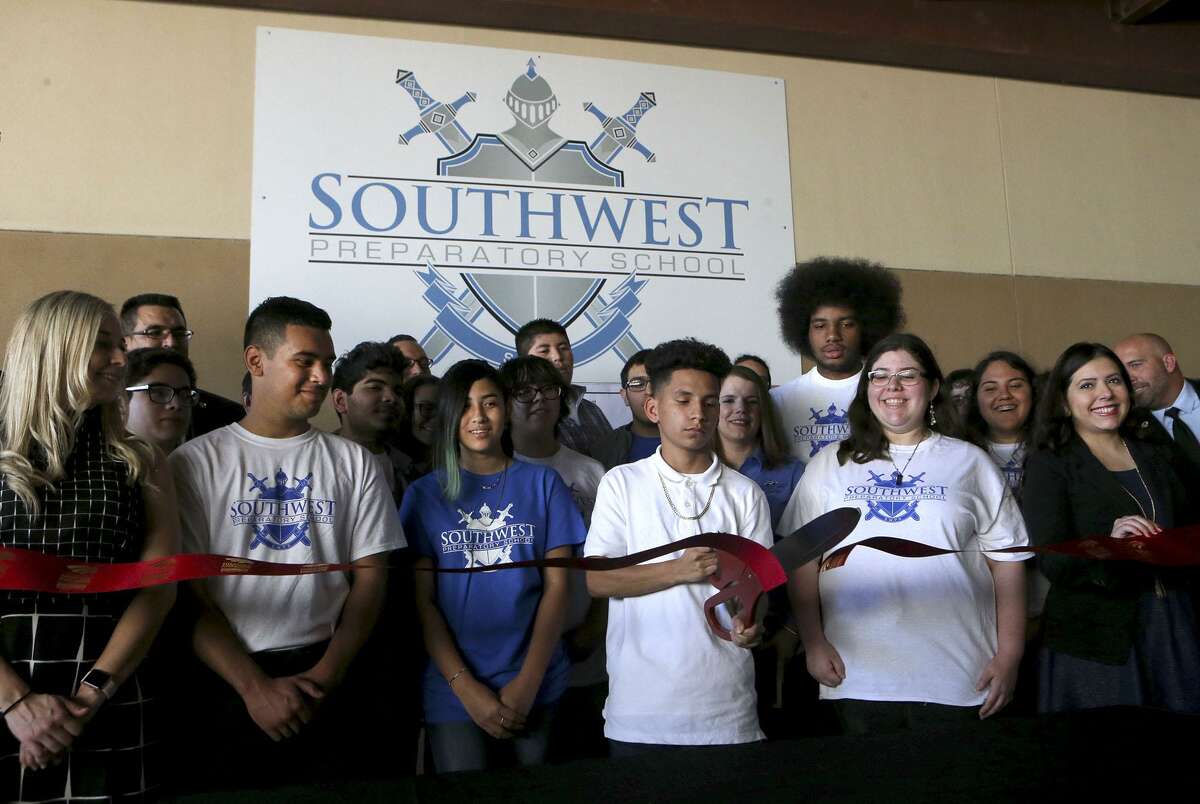 Jeremy Velasquez,14, (center, holding scissors) a ninth grader at Southwest Preparatory School, cuts a ribbon after the announcement of the Early College High School Partnership between Southwest Preparatory's Northwest Campus and Texas A&M-San Antonio. The new ECHS will allow students to earn up to 60 credit hours toward a four-year degree by taking classes at the TAMUSA campus.