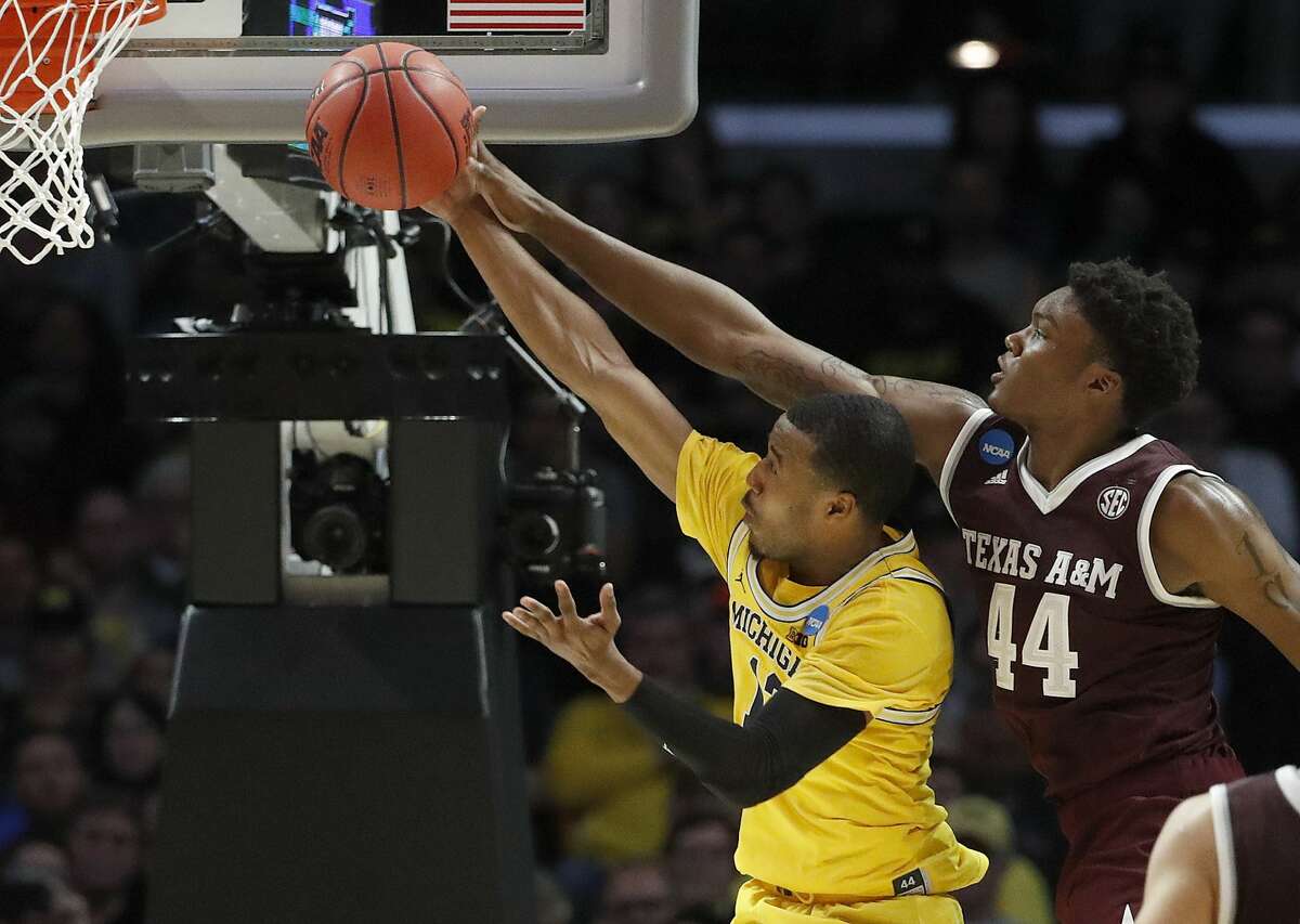 Michigan guard Muhammad-Ali Abdur-Rahkman, left, shoots in front of Texas A&M forward Robert Williams during the second half of an NCAA men's college basketball tournament regional semifinal Thursday, March 22, 2018, in Los Angeles. (AP Photo/Jae Hong)
