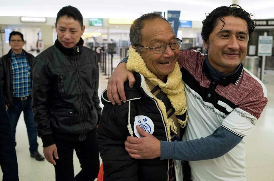 Kamal Sharma, right, of Columbus, embraces his relative Til Gurung, a Bhutanese refugee from Nepal, as he and other relatives arrive at the John Glenn Columbus International Airport in Columbus, Ohio on Thursday, Feb. 15, 2018. Two families of Bhutanese refugees met with their family members at the Columbus Airport after an 18 hour flight from Nepal where the families lived in the Beldangi Refugee Camp in Jhumpa, Nepal. Bhutanese refugees, most who are Buddhist or Hindu and were expelled during a government-led ethnic cleansing campaign against ethnic Nepalis in the early 1990s. (AP Photo/Ty Wright) Photo: Ty Wright / FR170125 AP
