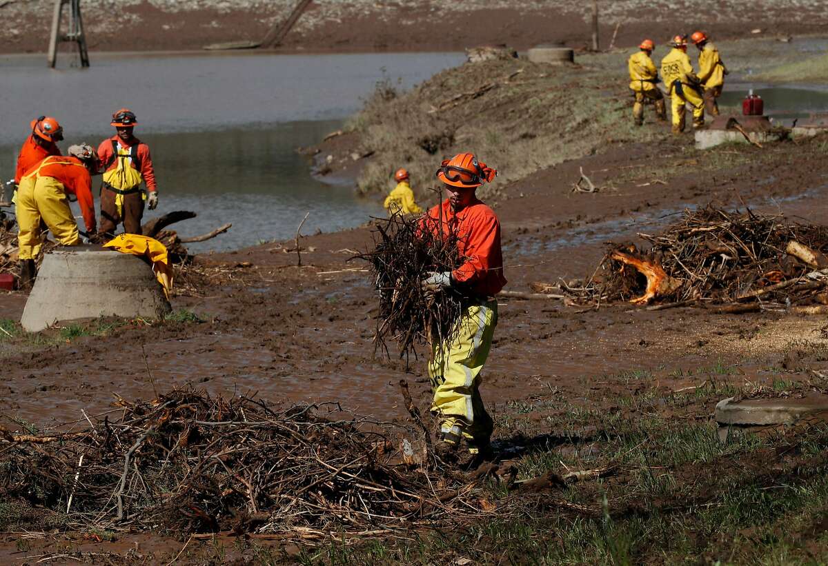 Inmate firefighters from Baseline Camp help with the debris clean up of Moccasin reservoir, in Moccasin, Calif., as seen on Fri. March 23, 2018. Officials issued a flash flood warning Thursday for south central Tuolumne County due to �imminent dam failure� at Moccasin Reservoir Dam in Tuolumne County.