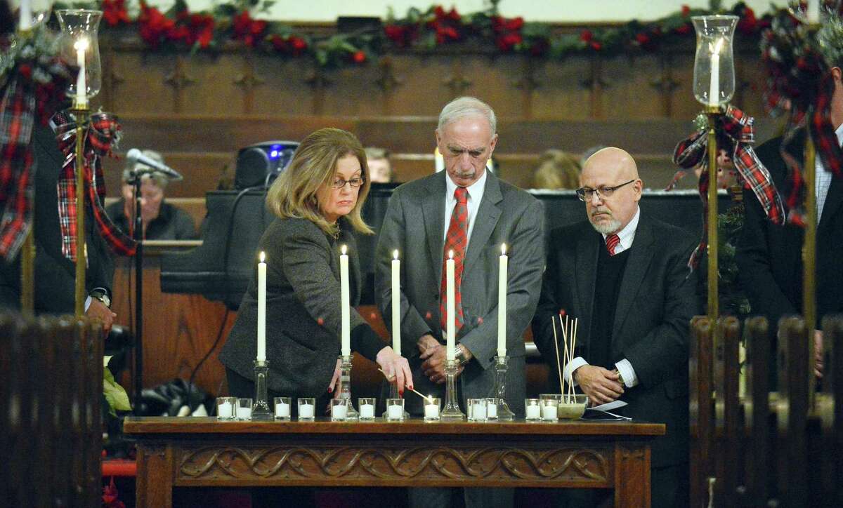 Linda Autore, Execuetive Director of Laurel House, lights one of 13 candles representing those who have died homeless in our community during a service at the First Congregational Church in Stamford, Conn. on Thursday, Dec. 21, 2017 on National Homeless Persons' Memorial Day 2017. Also pictured are Ludwig Spinelli, Execuetive Director of Optimus Health Care and Rafael Pagen, Excuetive Director of Pacific House.