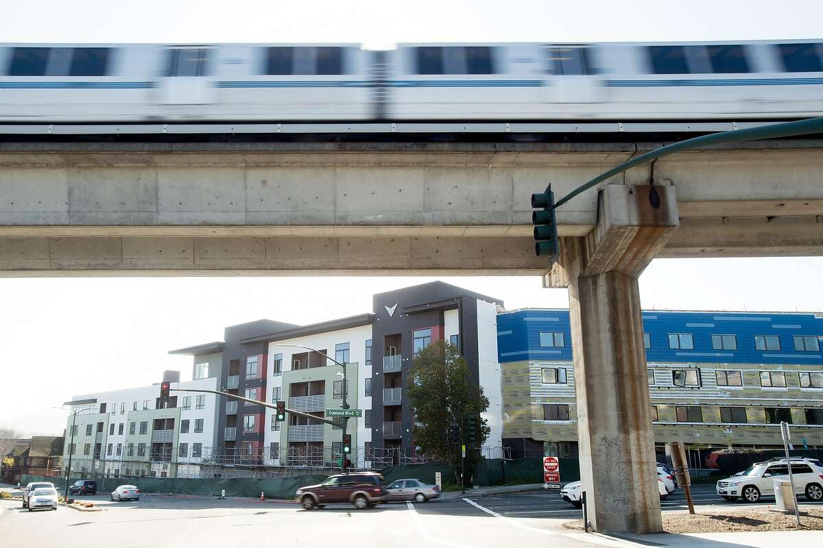 A BART train passes the Vaya housing project, a 178 unit transit-oriented development slated to open this year in Walnut Creek, Calif. A bill to increase housing development near BART stations squeaked past the state Senate on Thursday.