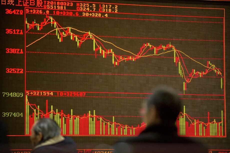 Chinese investors monitor stock prices at a brokerage house in Beijing, Friday, March 23, 2018. Fears of a trade war roiled financial markets and sent the dollar wobbling Friday after Beijing retaliated against the Trump administration's tariff hikes by threatening import duties on U.S. goods. (AP Photo/Mark Schiefelbein) Photo: Mark Schiefelbein / Copyright 2018 The Associated Press. All rights reserved.