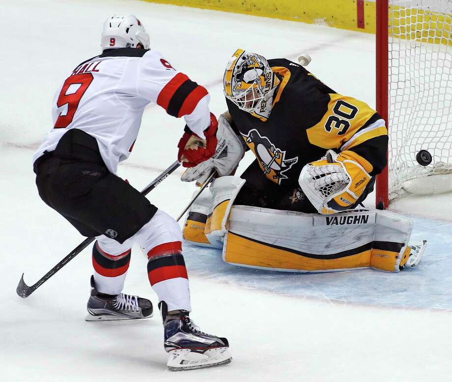 New Jersey Devils' Taylor Hall (9) puts the puck behind Pittsburgh Penguins goaltender Matt Murray (30) for an overtime goal during an NHL hockey game in Pittsburgh, Friday, March 23, 2018. The Devils won 4-3. (AP Photo/Gene J. Puskar) Photo: Gene J. Puskar / Copyright 2018 The Associated Press. All rights reserved.
