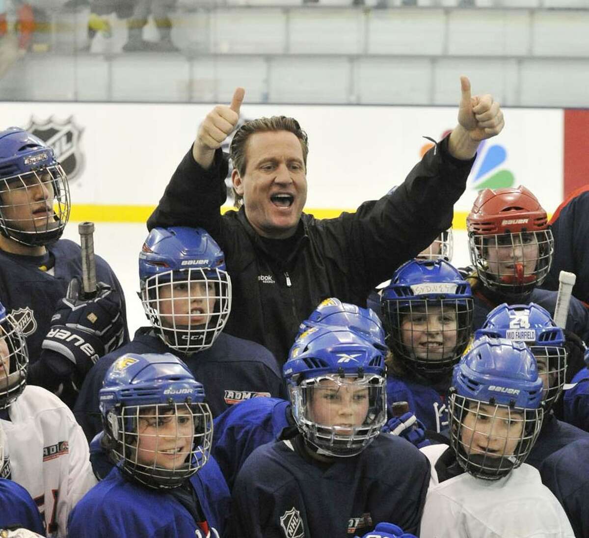 Jeremy Roenick, former NHL player and current NBC commentator, poses with kids at the end of Hockey Day in America at Chelsea Piers in Stamford, Conn., on Sunday, March 2, 2014.