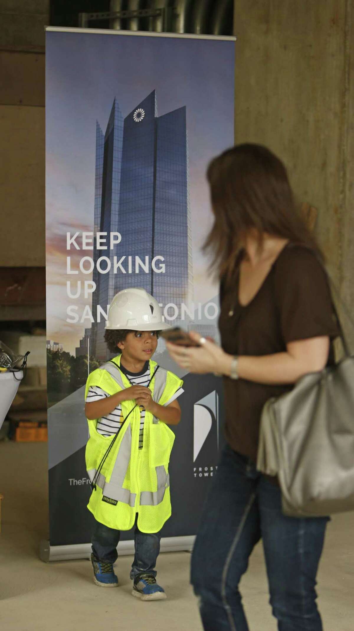Silas Washington,9 walks away after having his photo taken by mom Collen Washington. More than 50 children got a ?“golden ticket?” to take part in ?“Journey into Frost Tower,?” an event sponsored by Weston Urban and KDC Real Estate Investments. The children will don hard hats and safety attire to lay bricks for the tower. Before that, they?’ll be able to take a virtual reality of the tower and build a replica of the tower using Legos.on Sunday, March 25 ,2018