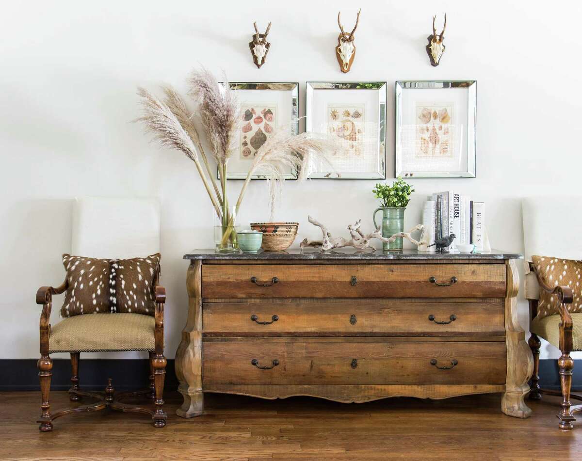 Odd numbers: While there are no hard and fast rules in design, Jana Erwin likes to work in odd numbers. So this dresser has three pieces of art above it, and each has one German deer skull.