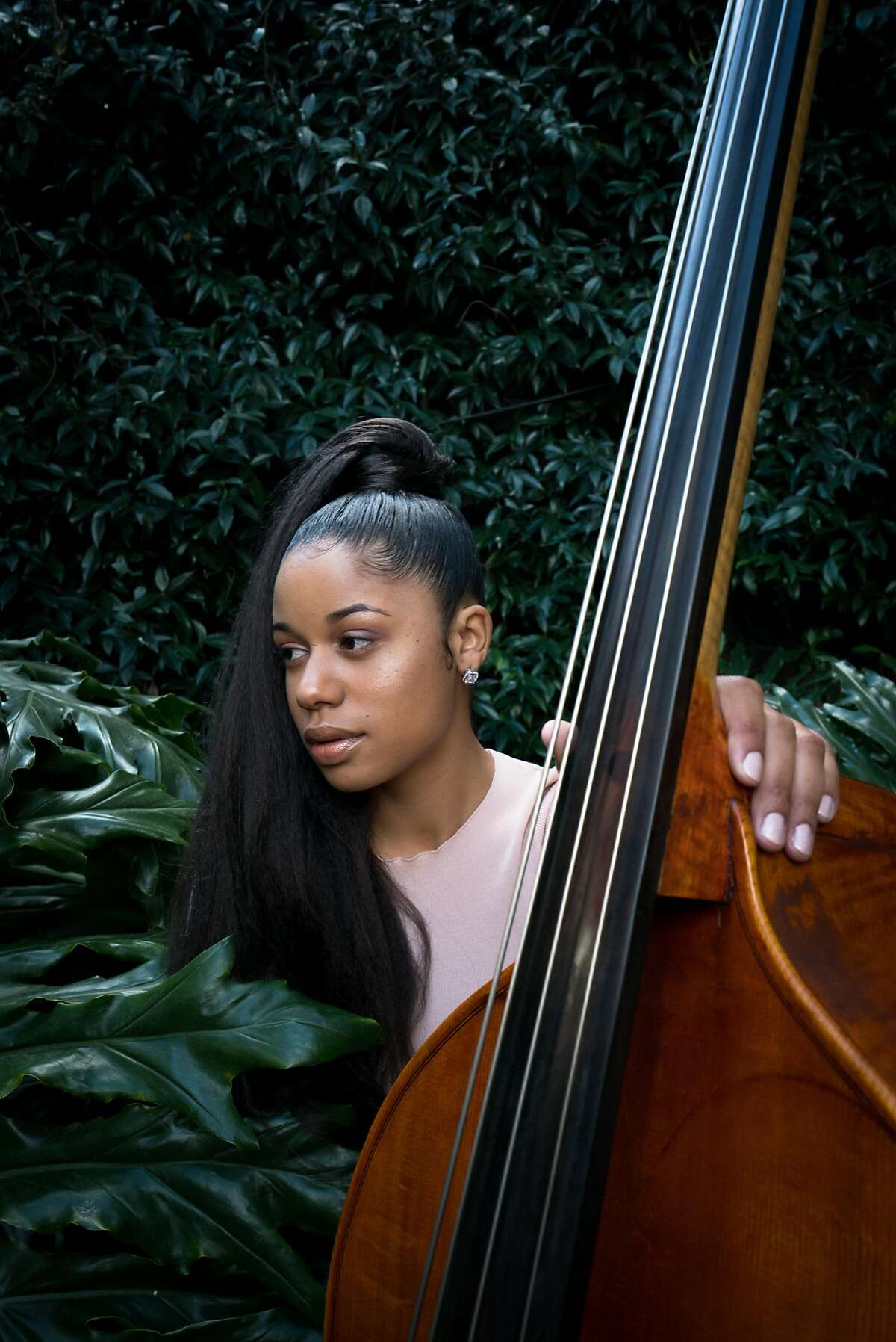 Aneesa Strings, 25, sits with the standup bass at Zoo Labs non-profit recording studio in Oakland, Calif. on Saturday, March 24, 2018.