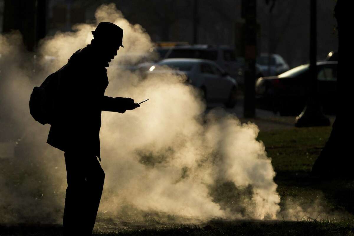 In this Nov. 30, 2012 photo, a pedestrian looks at his phone near steam vented from a grate near the Philadelphia Museum of Art on a cold morning in Philadelphia. Every time a person shops online or at a store, loyalty cards linked to phone numbers or email addresses can be linked to other databases that may have location data, home addresses and more. Voting records, job history, credit scores (remember the Equifax hack?) are constantly mixed, matched and traded by companies in ways regulators havent caught up with.