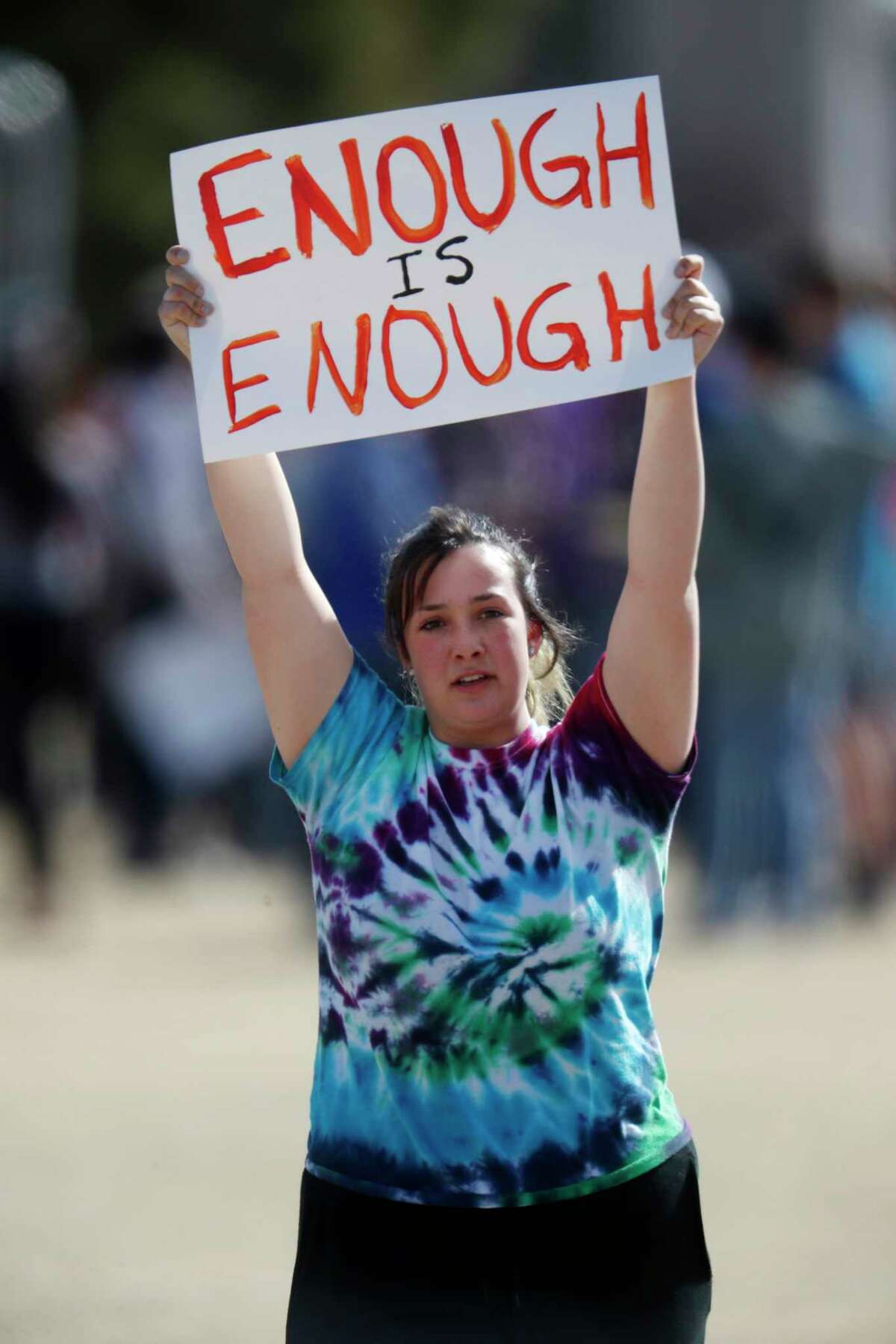 Fifteen-year-old Leah Zundel, a sophomore at Columbine High School, carries a sign during a student walkout to protest gun violence on the soccer field behind the school Wednesday, March 14, 2018, in Littleton, Colo. More than 250 students took part in the short protest at Columbine, the scene of a mass school shooting on April 20, 1999. (AP Photo/David Zalubowski)