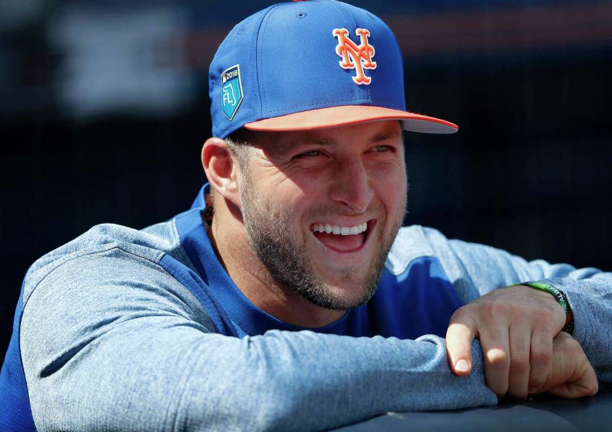 New York Mets' Tim Tebow laughs with teammates in the dugout before a spring training baseball game against the New York Yankees, Wednesday, March 7, 2018, in Port St. Lucie, Fla.. Tebow did not play. (AP Photo/John Bazemore)