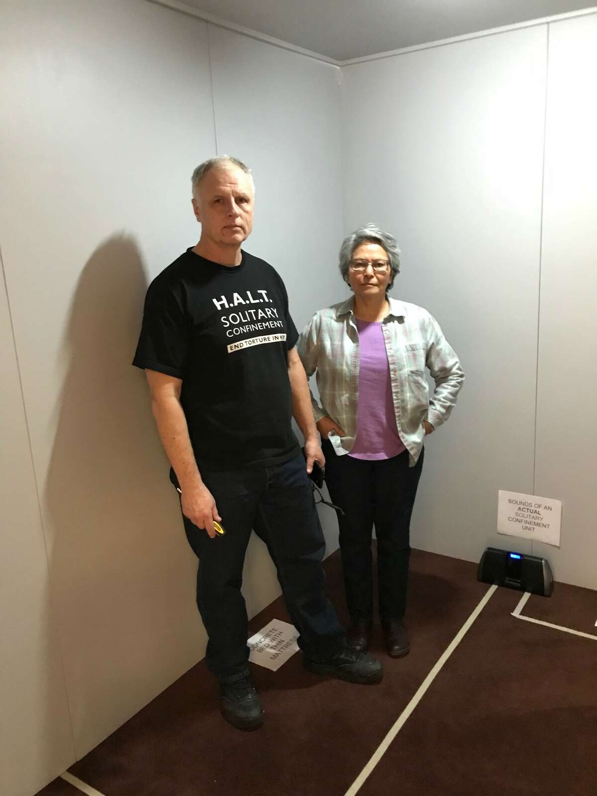 Alicia Barraza, left, and her husband, Douglas Van Zandt, inside a replica solitary confinement cell set up on Sunday, March 18 at Siena College for a performance of "The Exonerated."