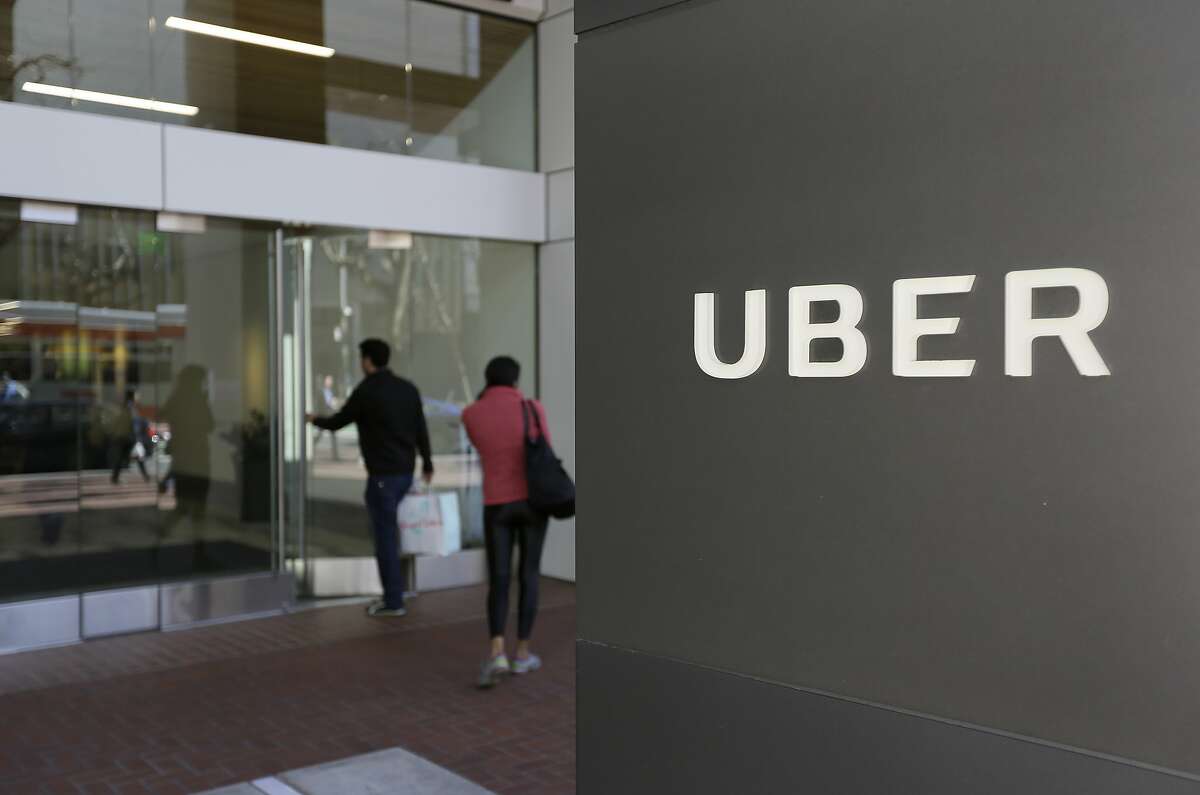 FILE - In this March 1, 2017 file photo, people enter the headquarters of Uber in San Francisco. Uber suspended all of its self-driving testing Monday, March 19, 2018, after what is believed to be the first fatal pedestrian crash involving the vehicles. The testing has been going on for months in the Phoenix area, Pittsburgh, San Francisco and Toronto as automakers and technology companies compete to be the first with the technology. Uber's testing was halted after police in a Phoenix suburb said one of its self-driving vehicles struck and killed a pedestrian overnight Sunday. (AP Photo/Eric Risberg, File)