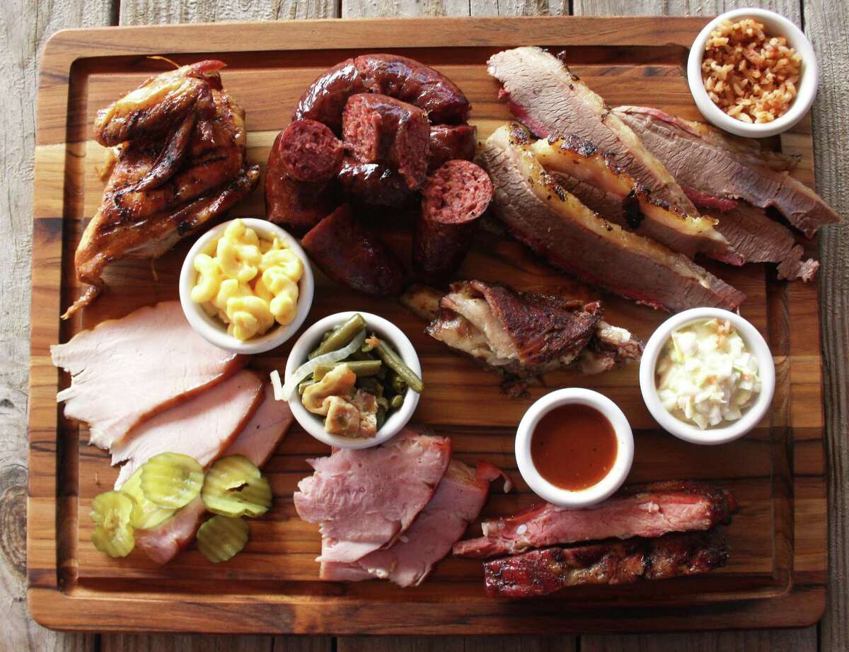 The Davila's BBQ board consists of (clockwise from top left) mesquite-smoked chicken, beef sausage, brisket, Spanish rice, cole slaw, spare ribs, lamb ribs, ham, green beans, turkey and mac and cheese.