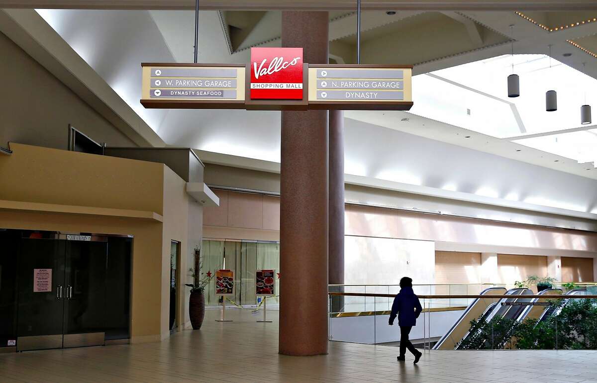 A woman walks through the Vallco shopping mall in Cupertino, Calif. on Wednesday, Feb. 14, 2018. Few tenants remain at the mall in the western Santa Clara Valley, including an AMC Theater and a couple of restaurants, but it is largely abandoned.