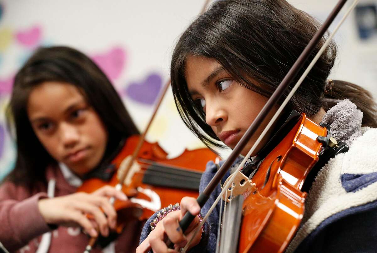 Keila Ambriz, (right) on violin in Sarah Moulder's 6th grade string orchestra class at Ravenswood Middle School in East Palo Alto, Calif. as seen on Tues. Mar. 27, 2018.