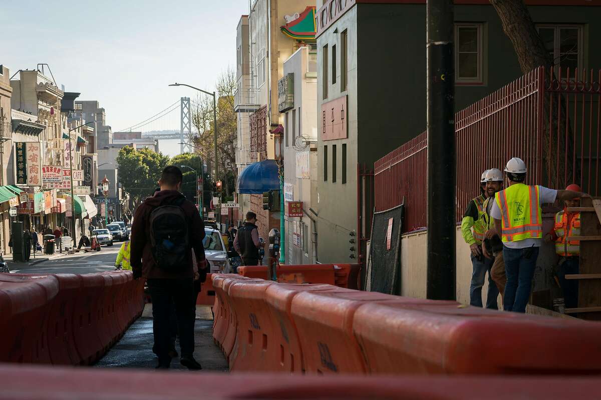 People walk past construction at the Ping Yuen housing development building in Chinatown in San Francisco, Calif. on Tuesday, March 27, 2018.