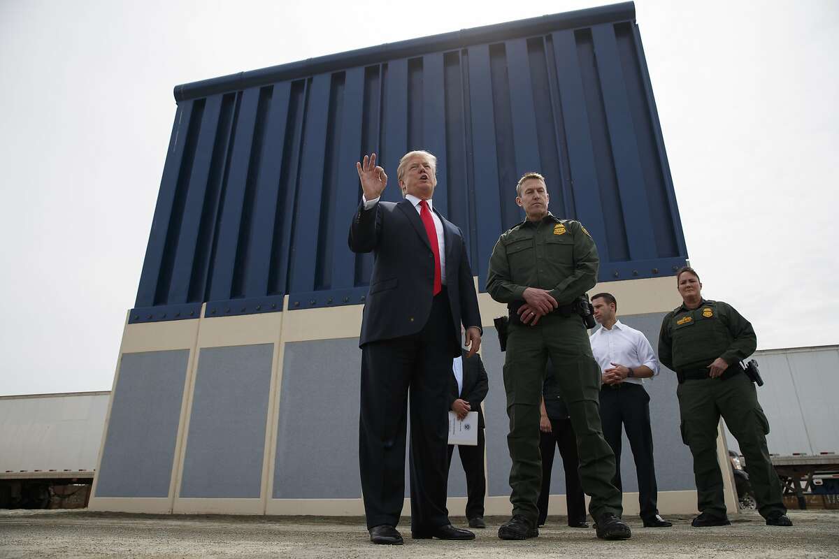 FILE - In this March 13, 2018 file photo, President Donald Trump talks with reporters as he reviews border wall prototypes in San Diego. Trump is floating the idea of using the military�s budget to pay for his long-promised border wall with Mexico. Trump raised the idea to House Speaker Paul Ryan at a meeting last week, according to a person familiar with the discussion who spoke on condition of anonymity. (AP Photo/Evan Vucci, File)