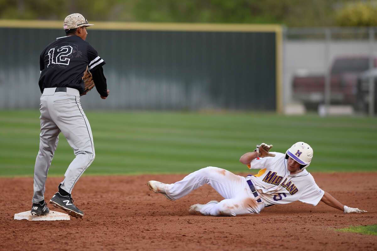 Midland High's Hunter Ingram (5) gets out at second base after sliding in against Permian's Noey Brito (12) March 27, 2018, at Zachery Field. James Durbin/Reporter-Telegram