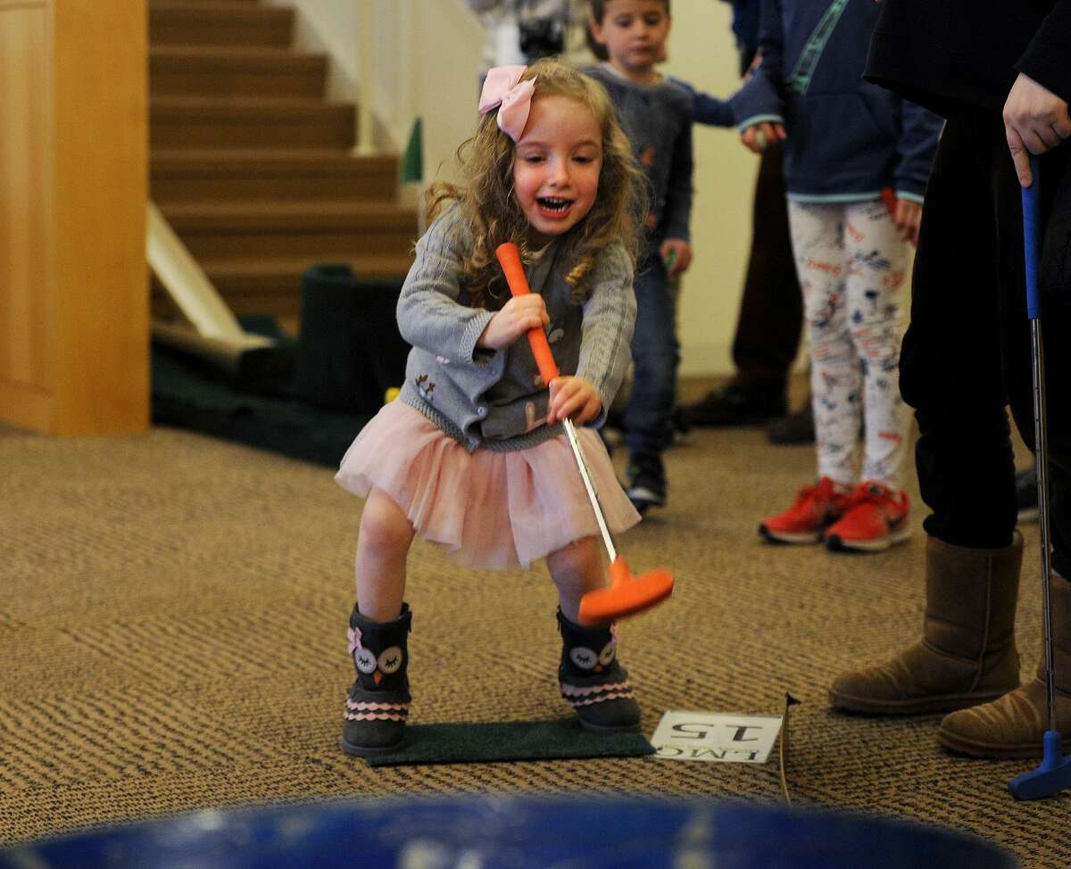 Abigail Herman, 4, of Fairfield, has fun during the Friends of the Library Mini-Golf fundraiser at the Fairfield Public Library in Fairfield, Conn. on Sunday, March 25, 2018. Holes were laid out through the stacks and down stairways and ramps throughout the building.