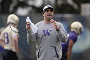 Washington offensive coordinator Bush Hamdan works with players at the first practice of spring football for the NCAA college team Wednesday, March 28, 2018, in Seattle. (AP Photo/Elaine Thompson)nam