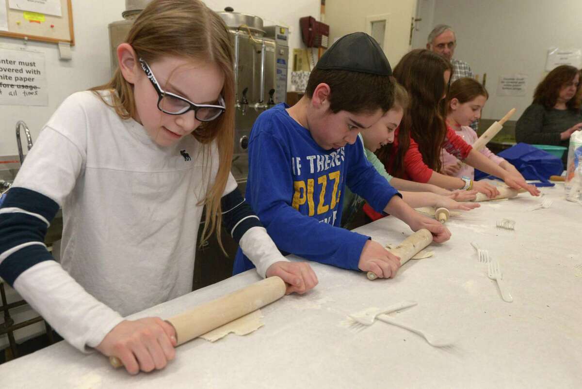 Congregation Beth El Rabbi Ita Paskind teaches students at their Hebrew school including Nina Rutherford, 11, and Robbie Eskenazi, 10, how to make matzo Tuesday at the synagogue in Norwalk. For the first time, Congregation Beth El-Norwalk has taken steps toward recognizing the increase in interfaith marriages, giving voting rights to family members who are not Jewish. In addition, it changed language regarding officers to be gender neutral.